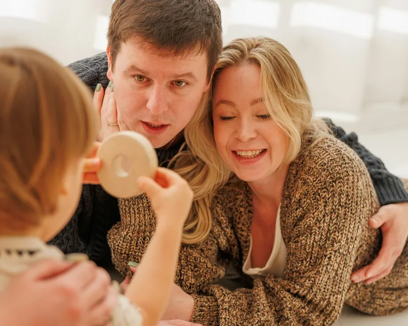 Des parents regardent leur enfant jouer, un moment calme à la maison